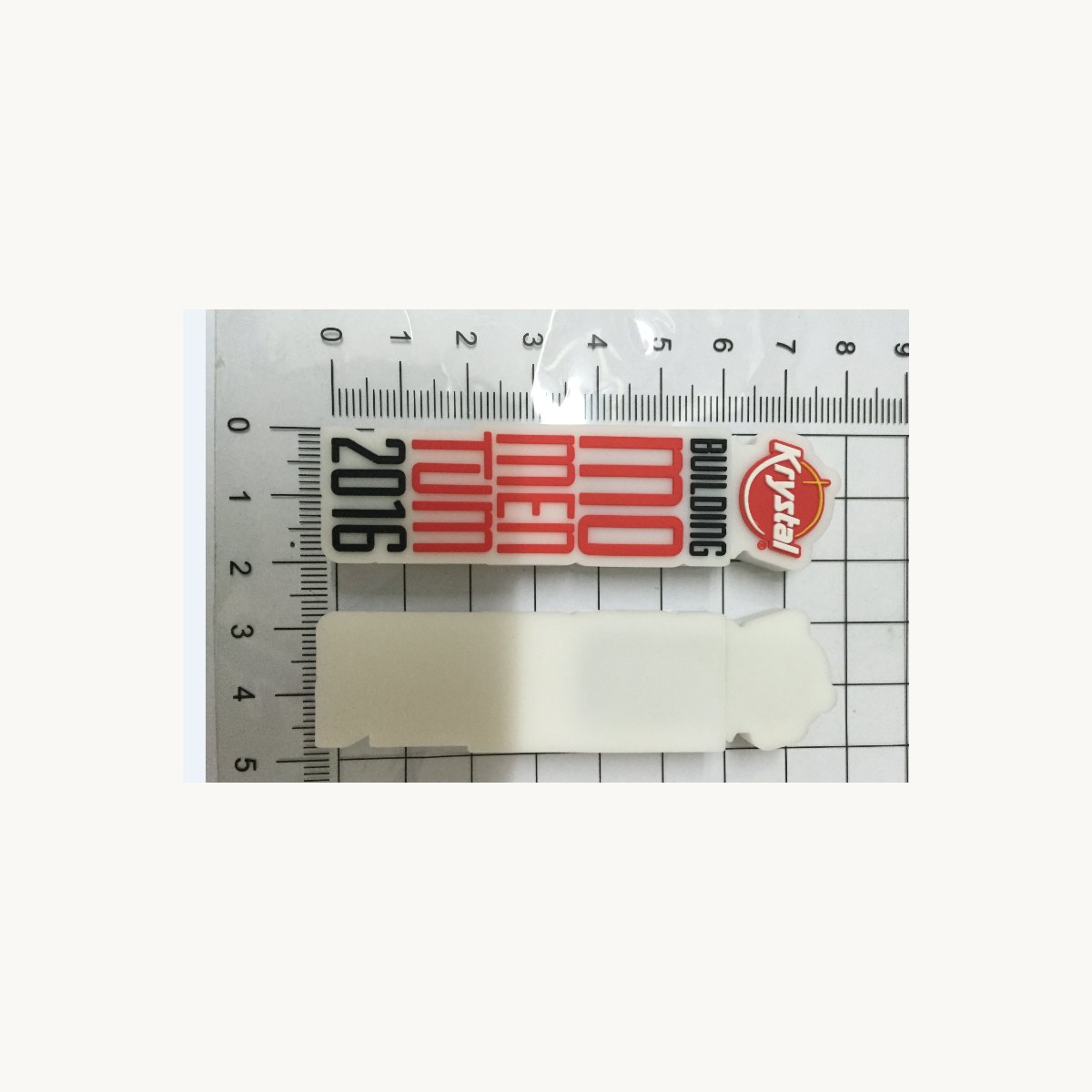 Tarjeta de PVC flexible impresa y una etiqueta blanca en blanco fotografiadas con regla