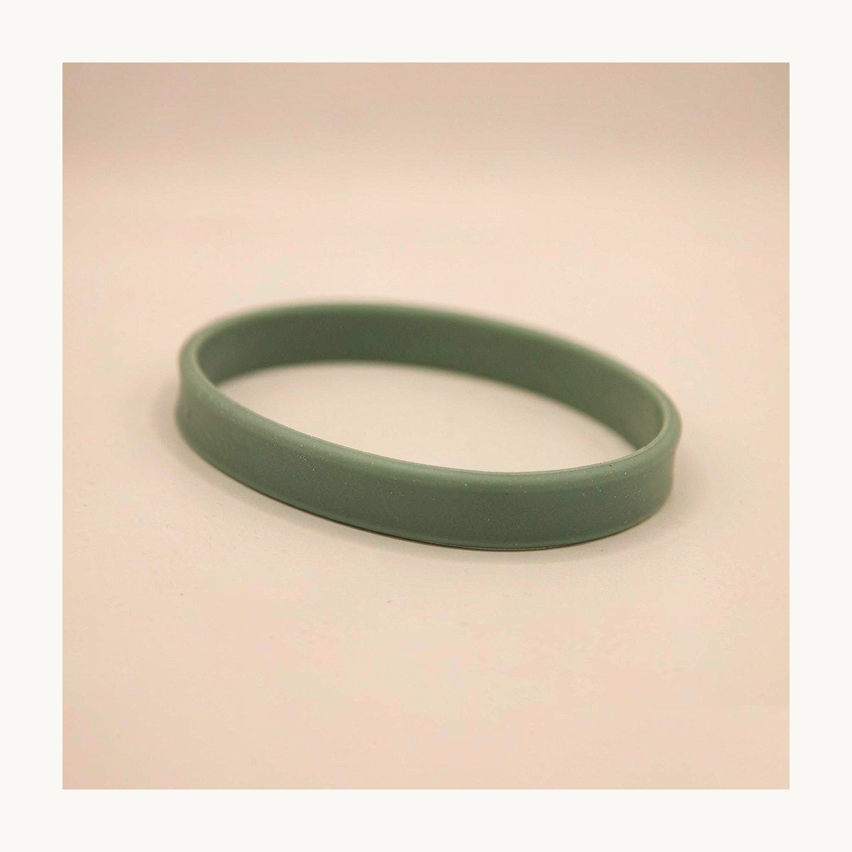 Primer plano de una pulsera de silicona apta para uso alimentario en verde salvia